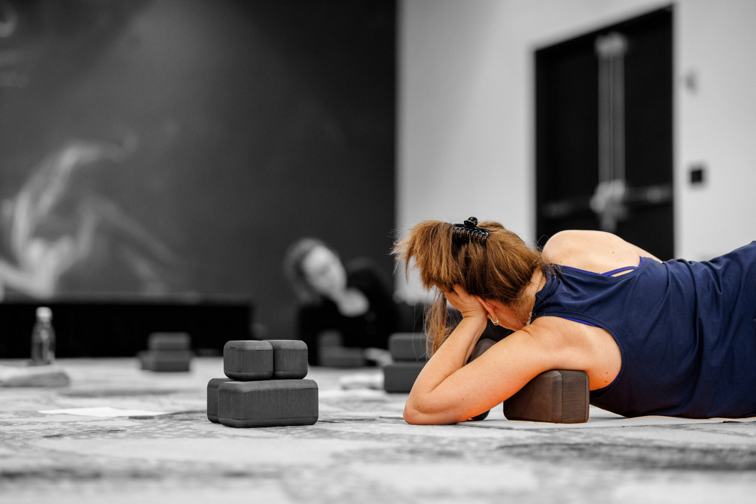 a woman in an unwind class lying on her side with an (un)Block in her armpit to release tension in her shoulders