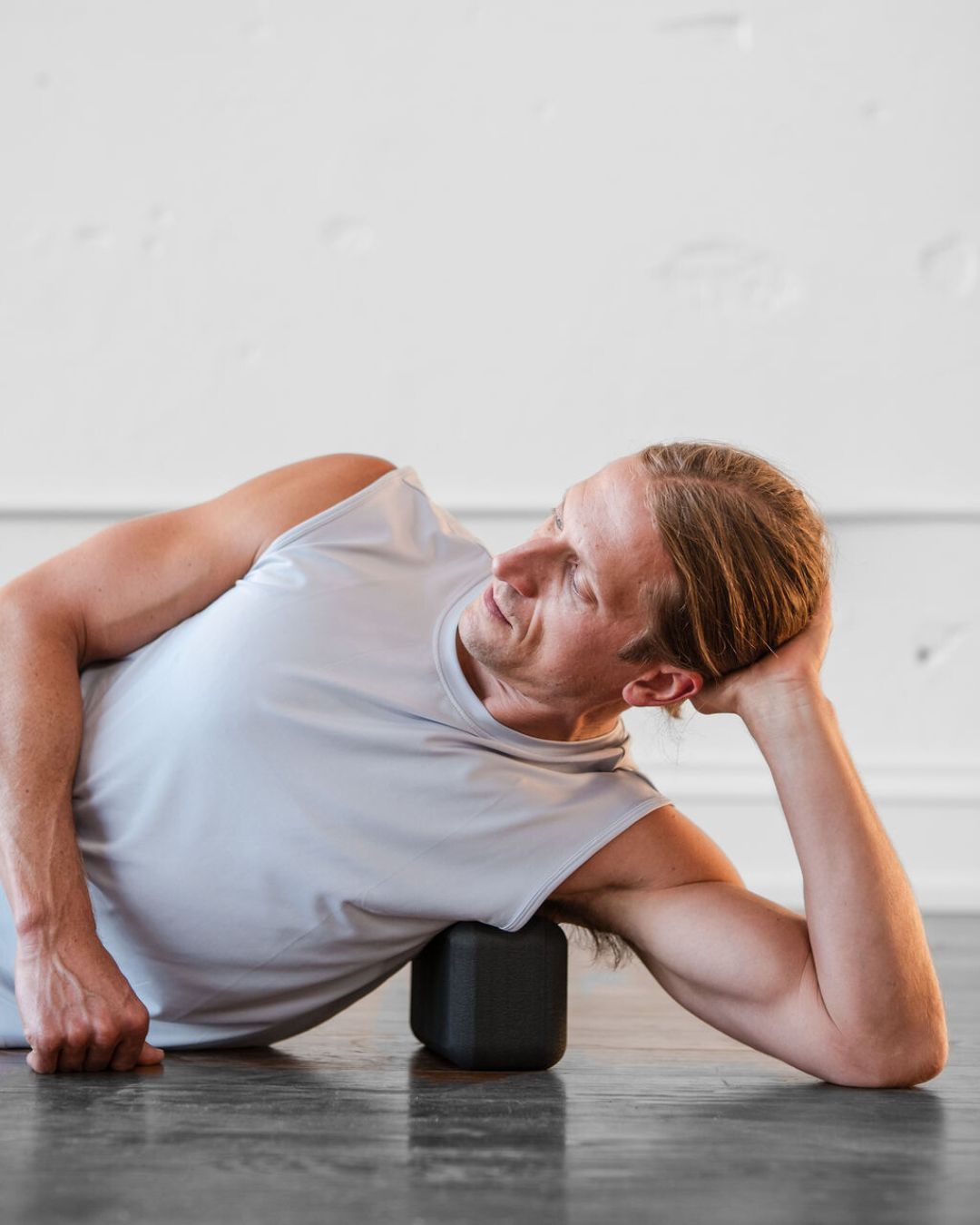 man side lying to use (un)Block in armpit to support shoulder and chest attachment points deltoids pectorals scapula and lymphatic drainage nodes