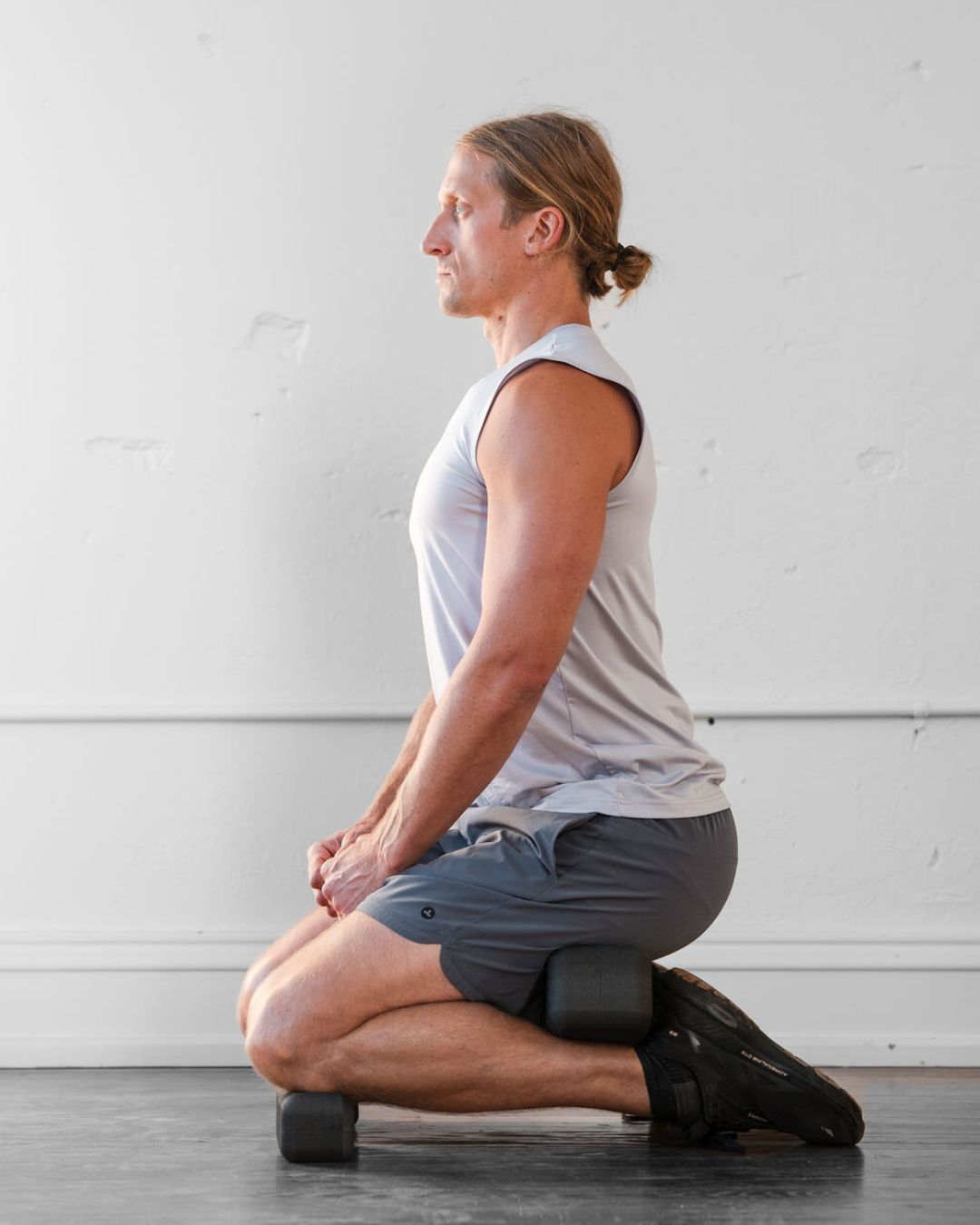 person using (un)Blocks kneeling to release tight hamstrings, calves, Achilles tendon, knee and patellar tendon